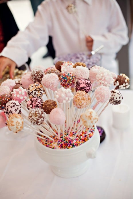 cake pops in a bowl of sprinkles