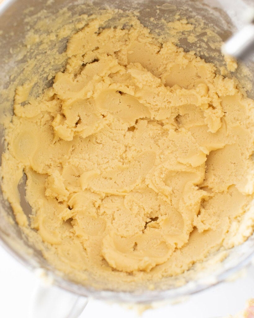Sugar cookie dough mixture in a stand mixer bowl.