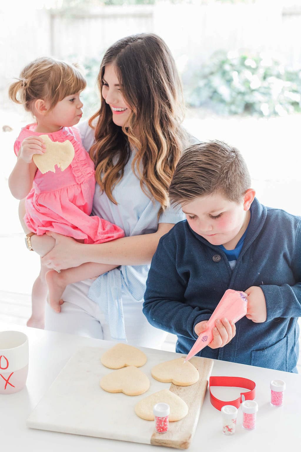 Mom and children decorating cookies.