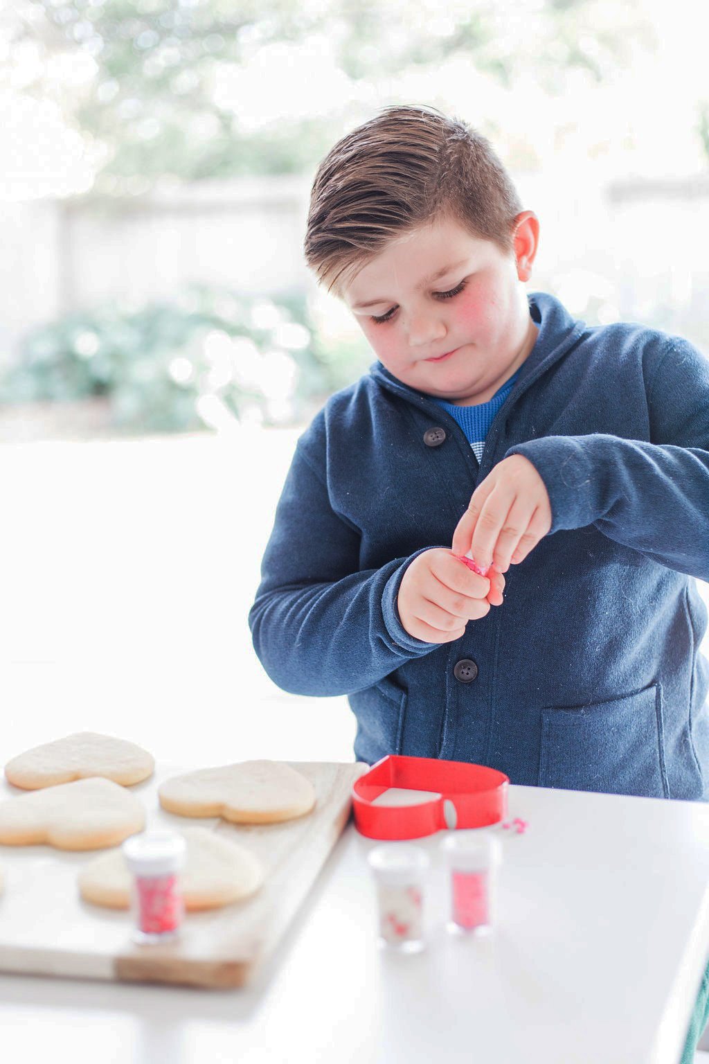 A small boy decorating cookies. 