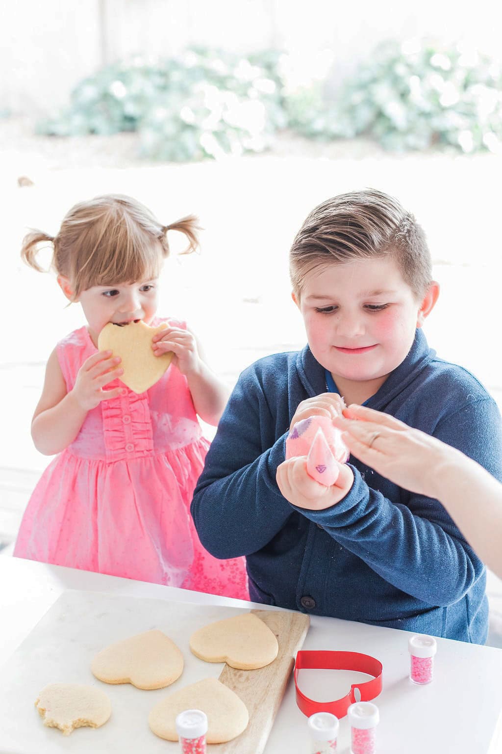 Two small children decorating cookies. 