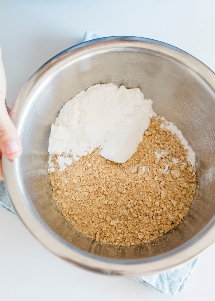 crushed graham crackers in bowl with white sugar for smores bars.