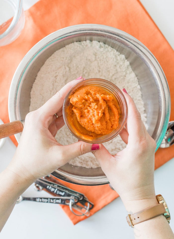 Adding pumpkin puree in the mixture for pumpkin pancakes.
