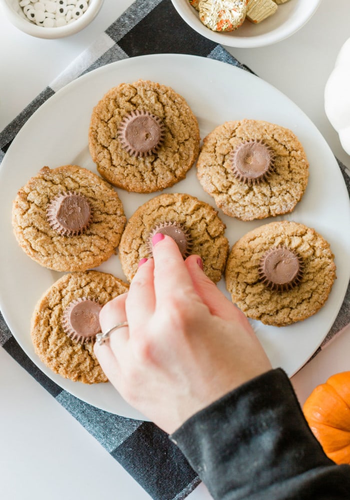 Peanut butter cookies topped with Reese’s cups for Halloween Spider Cookies.