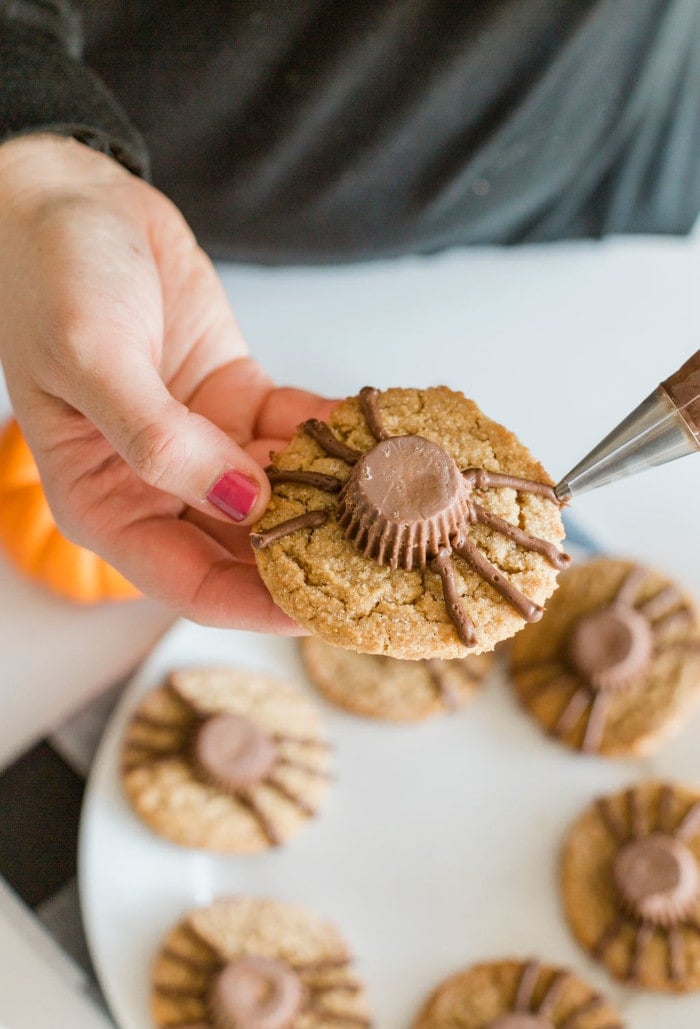 Adding chocolate frosting spider legs to Halloween Spider Cookies