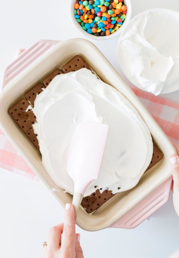 Smoothing Cool Whip on ice cream sandwiches