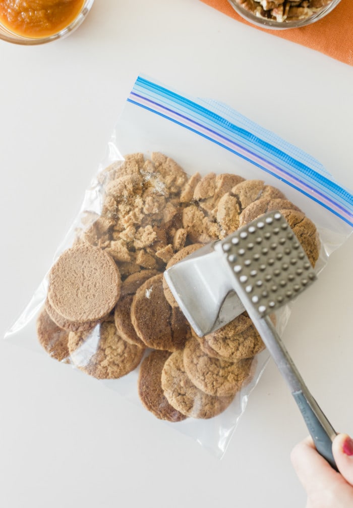 Crushing ginger snap cookies in a zip lock for pumpkin bar.