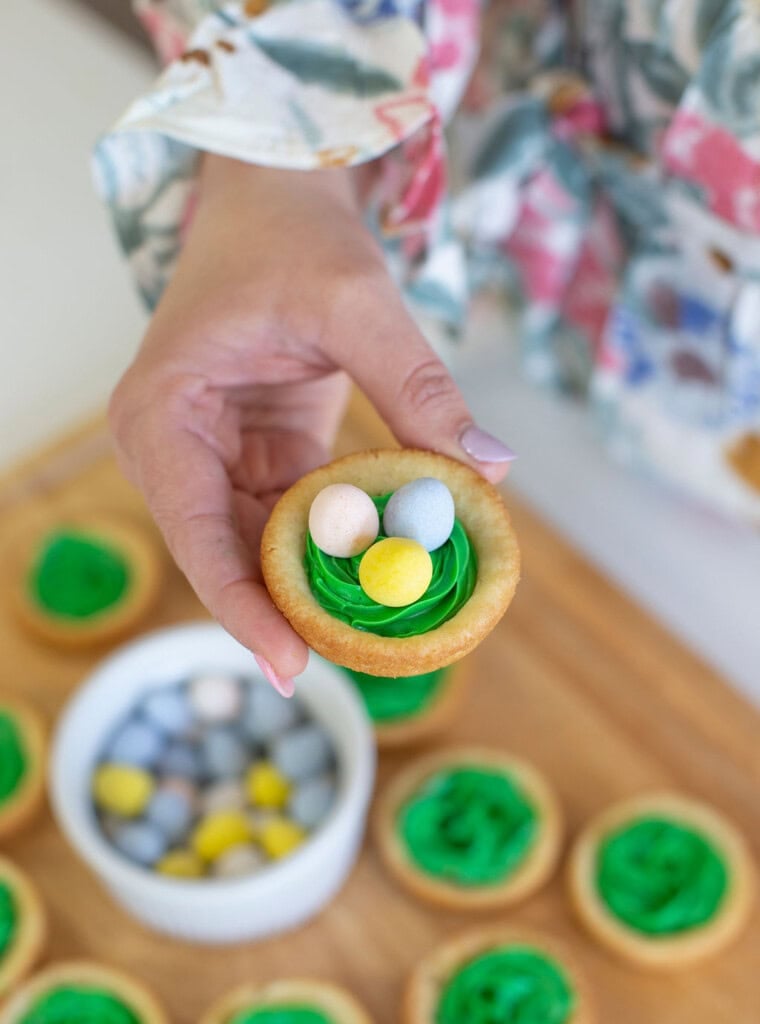 Easter birds nest cookie cup with green frosting for grass, and chocolate eggs.