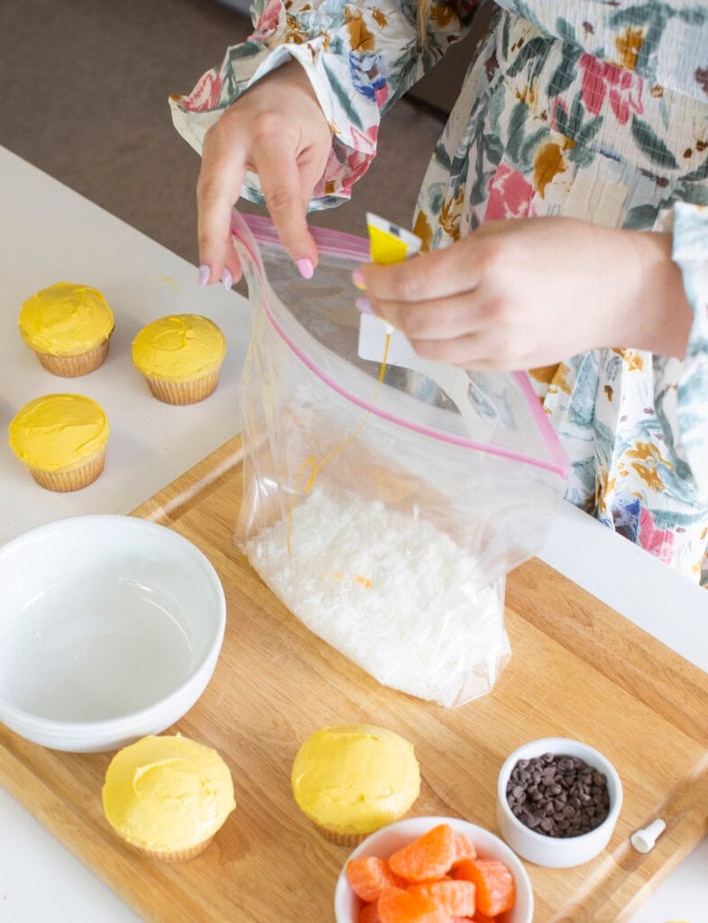 Process photo adding yellow food coloring to a bag of shredded coconut.