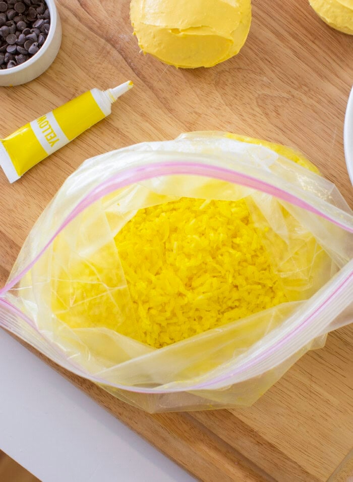 Process photo of yellow shredded coconut in a Ziploc bag.