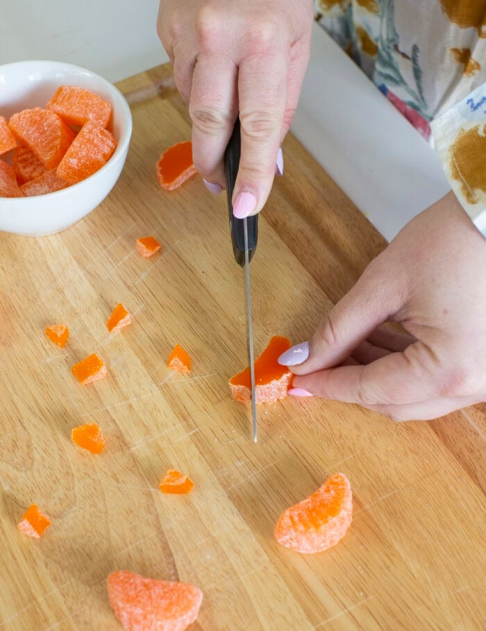 Process shot of cutting orange candy slices for the Easter chick cupcakes.