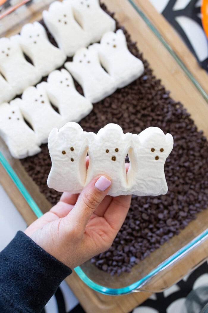 Adding ghost Peeps on top of the chocolate for the s’mores dip.