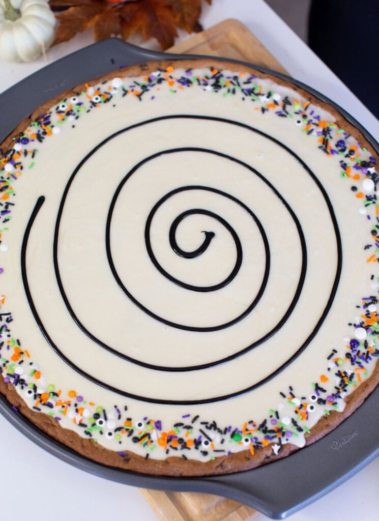 Adding spider web design to top of cookie over the frosting.