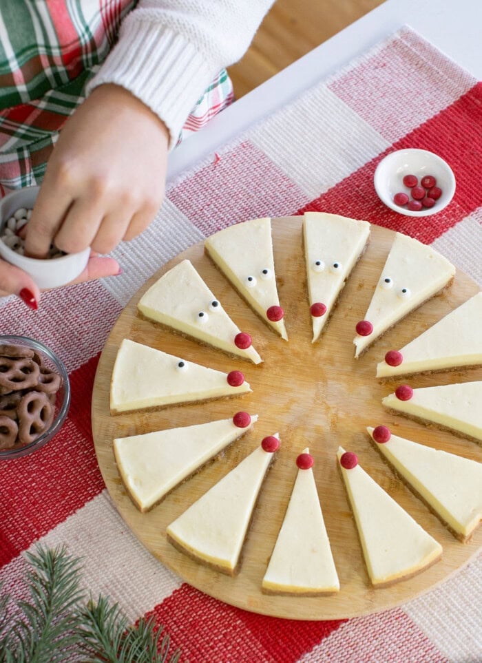 Reindeer cheesecake slices decorated with candy eyes and red noses, making a cute addition to your Christmas desserts.