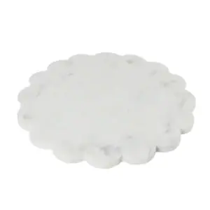 A round white marble slab with a scalloped edge, resembling a flower shape, placed on a plain white background.